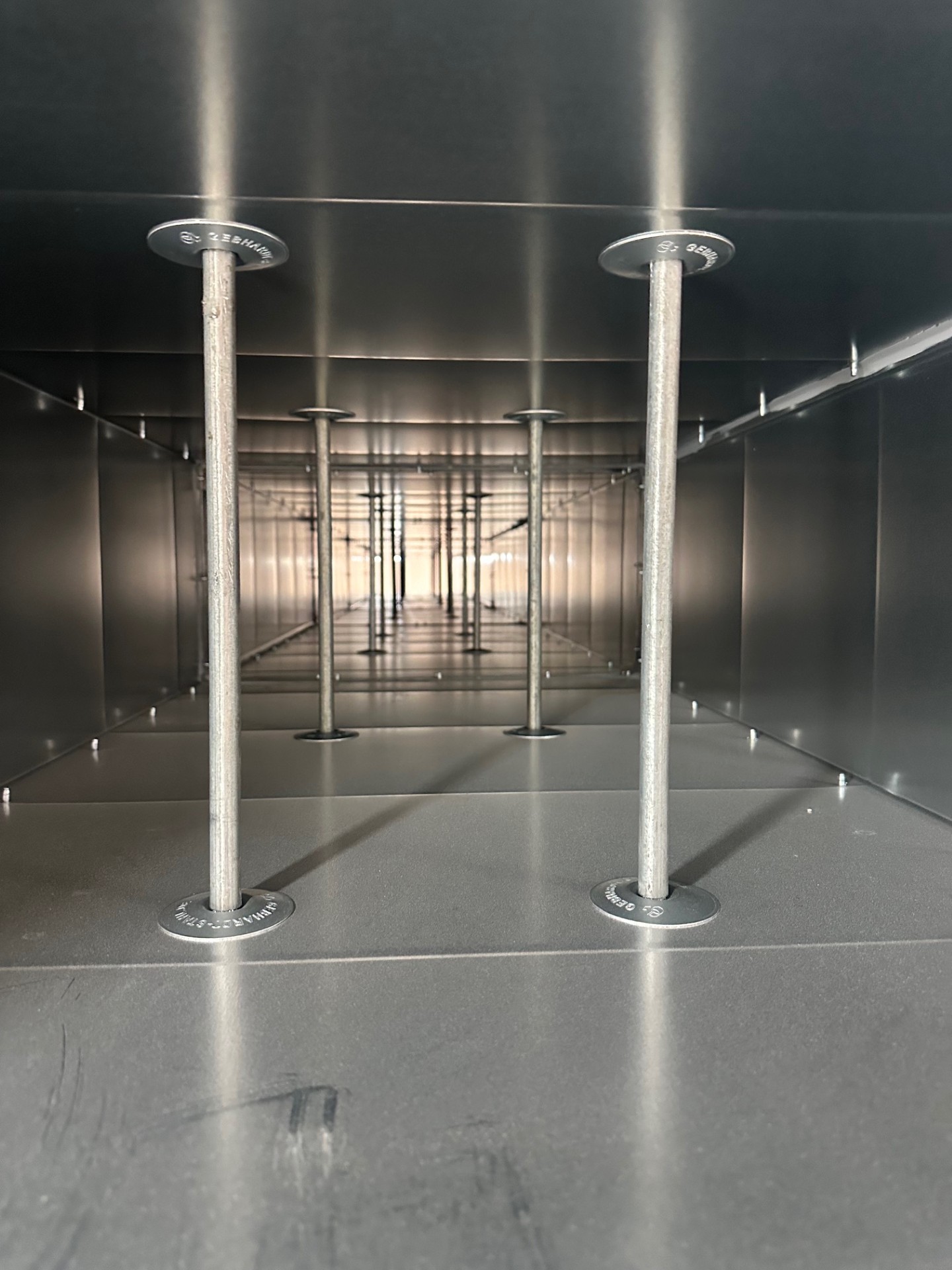 Internal view of rectangular smoke ductwork showing stiffening rods and large-area washers